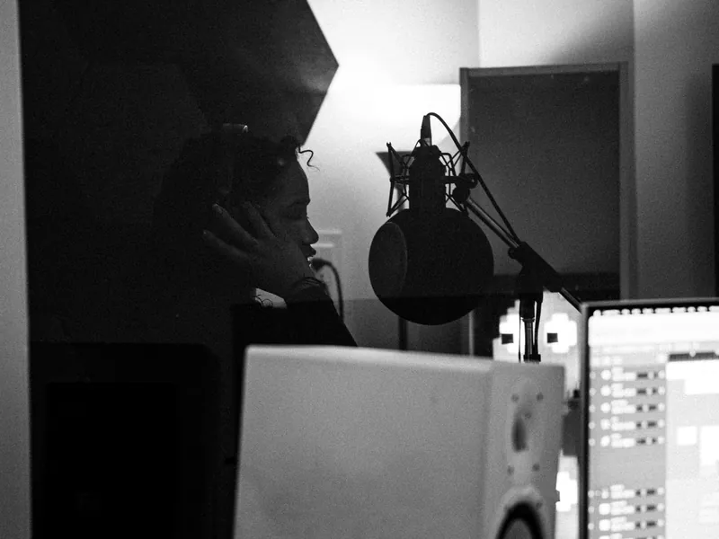 Vocalist monitoring a recording session in a studio